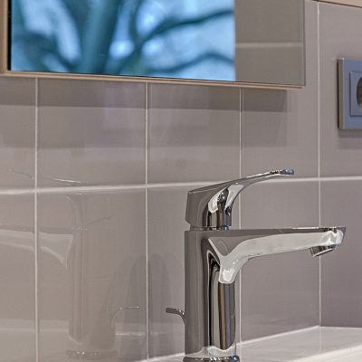 A silver faucet installed on the bathroom sink