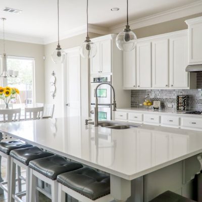 Spacious modern kitchen with white cabinets and island in natural light.