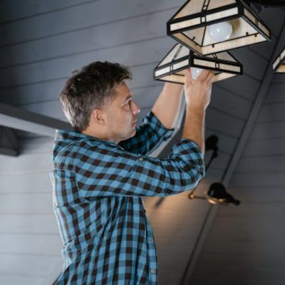 A Man Fixing Pendant Lights at Home